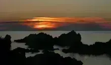 Sunset over rocks in the ocean from Sado Island